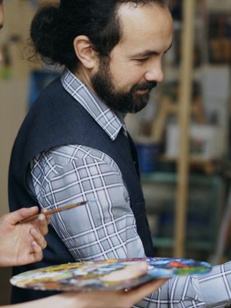 Deux personnes peignant ensemble sur une toile en atelier